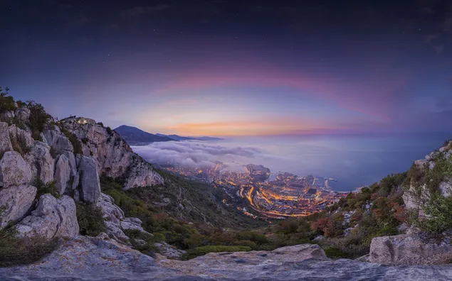 Zee en natuurlijk rotsachtig landschap onder bewolkte regenboogkleurige lucht voor Apple-producten en macos