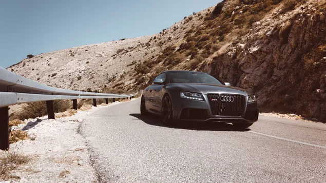 Zwarte Audi RS5-auto passeert op asfaltweg download